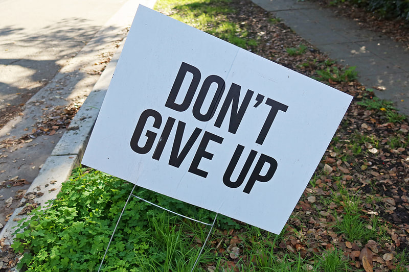 sign saying don't give up