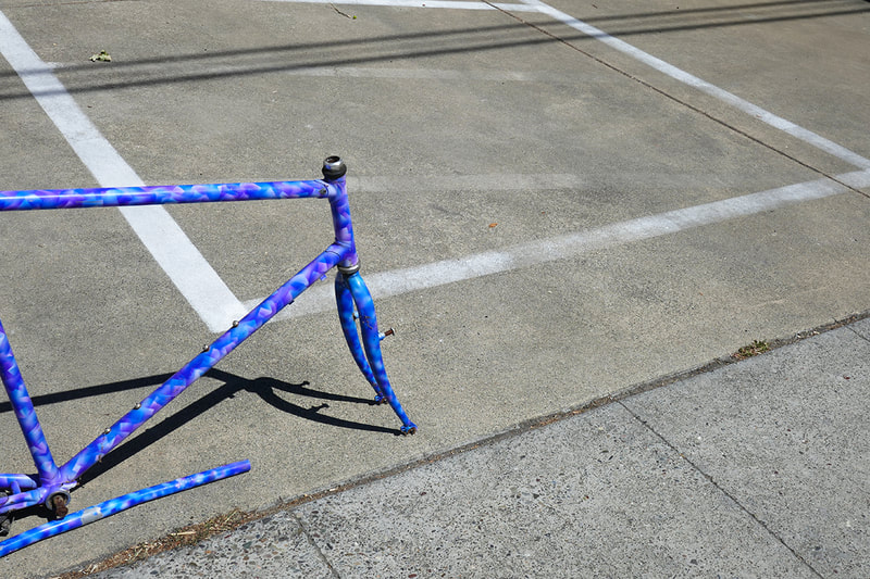 blue bicycle frame in parking lot