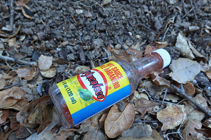hot sauce bottle on the ground