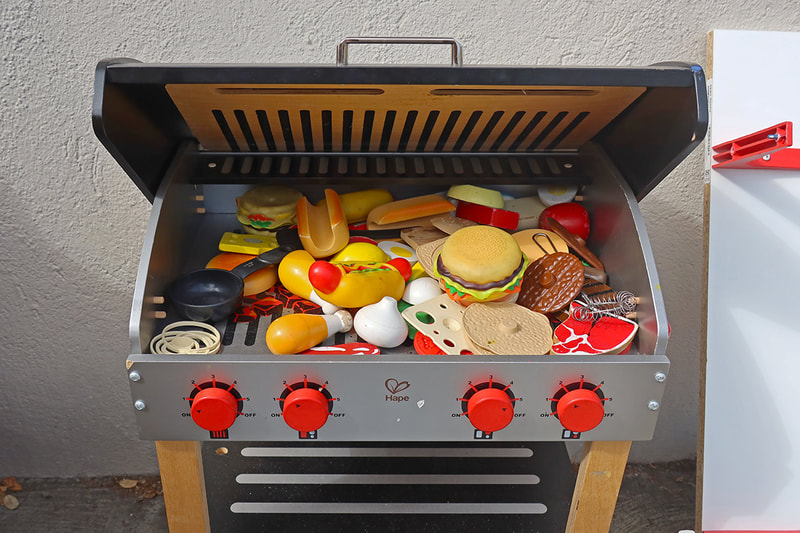 plastic toy food on toy grill