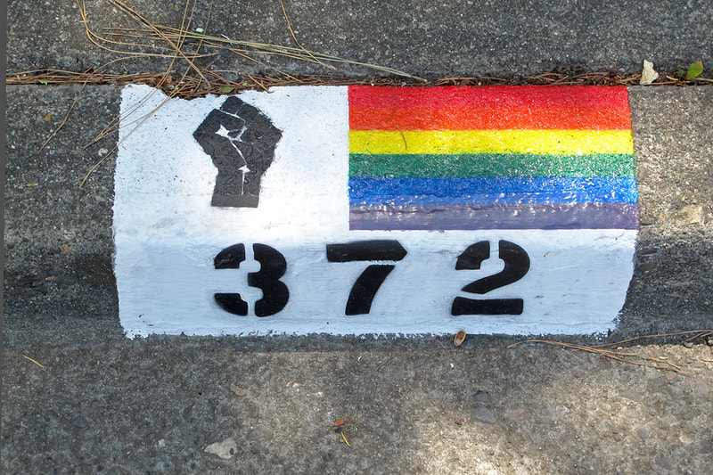House number with black power fist and rainbow bride flag
