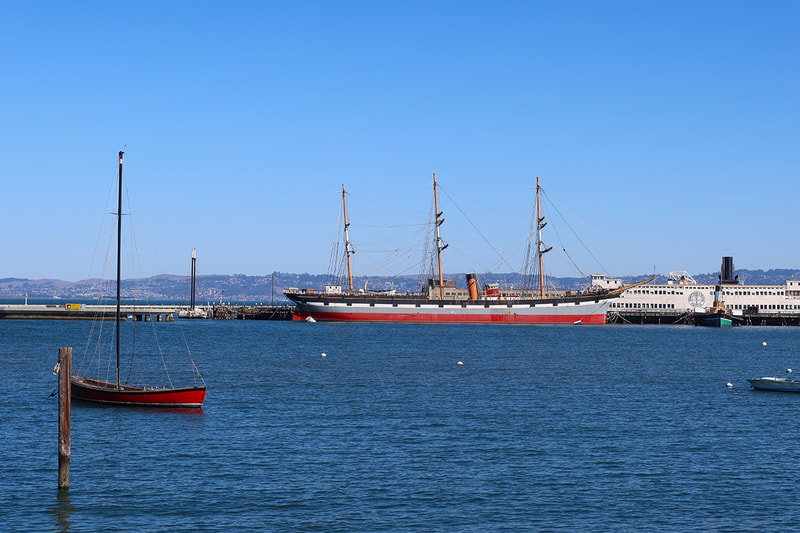 red sail boat and red ship