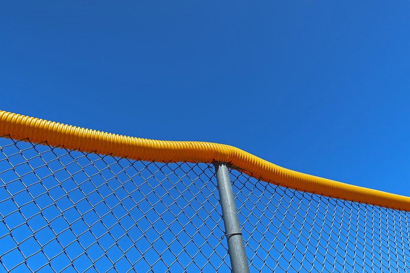 yellow tube on chain link fence