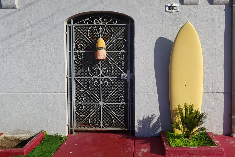 yellow surfboard by door 