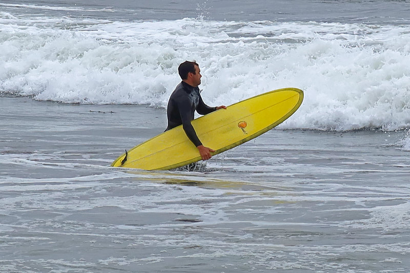 surfer with yellow board